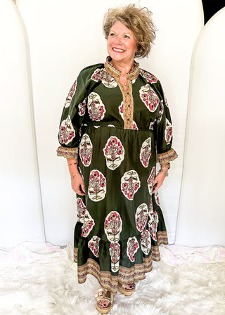 Palm green maxi dress with colorful floral medallion print, orange embroidered trim at neckline, and smocked cuffs