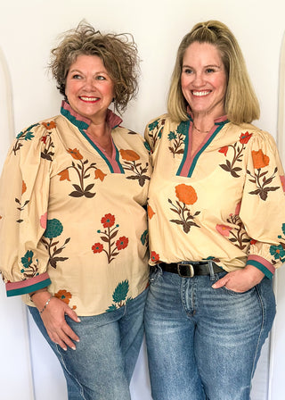 Ecru floral blouse with colorful flowers, contrast turquoise and rose trim, and ruffled neckline