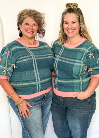 Turquoise plaid short sleeve sweater with pink trim and bow accents on the sleeves.