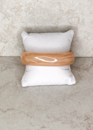 Sand bangle bracelet displayed on a stand 