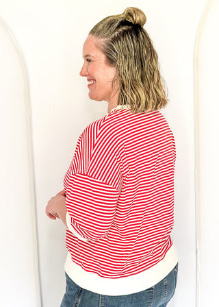 Striped knit dolman top with crew neckline and ribbed trim in red.