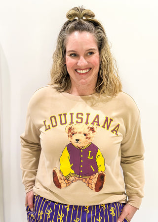 Tan long sleeve pull over with "LOUISIANA" in curved bold font above Benny the Bear in his Louisiana purple and gold letter jacket.  