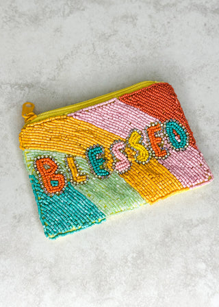 Colorful beaded pouch with 'Blessed' text on a gray surface
