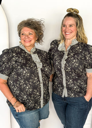 Black with small white florals-short sleeve button up top. Black and white stripe ruffle collar and sleeve binding.  