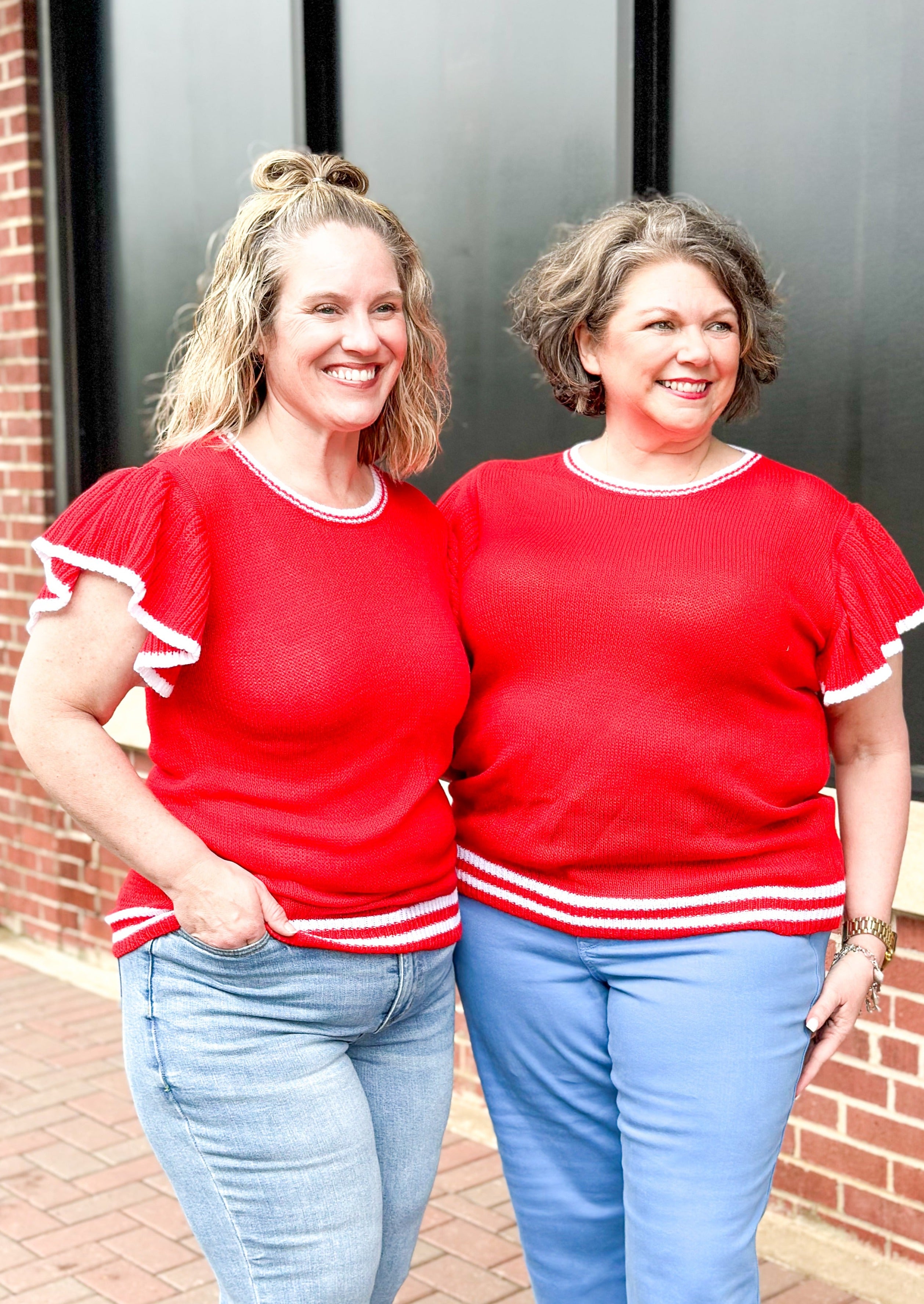 Short flutter sleeve red sweater with white trim around sleeve, neckline and bottom