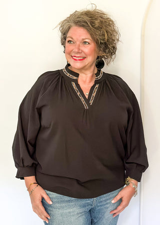 Textured black blouse with leopard lace detail on v-neckline and cuffs.