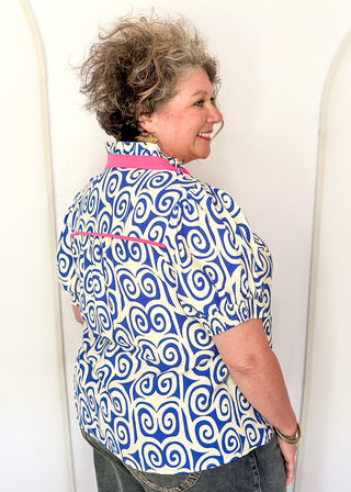 Royal blue swirl print top featuring pink contrast trim, puff sleeves, and lightweight relaxed fit.