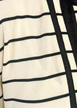 Close up of cream and black striped dolman top with black trim and flowy short sleeves.