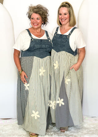 Two women modeling a denim overall style dress with gingham floral pattern.