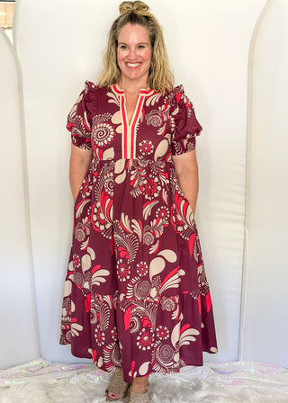 Plum floral maxi dress with short sleeves and v-neck. Collar has contrast piping in light brown and coral. 