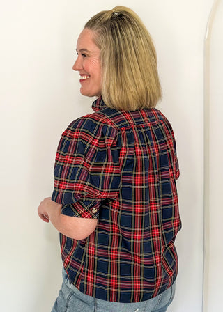 side view of woman wearing a short sleeve button up top in Navy/Red plaid