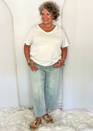 woman wearing denim crop jeans and white tee.