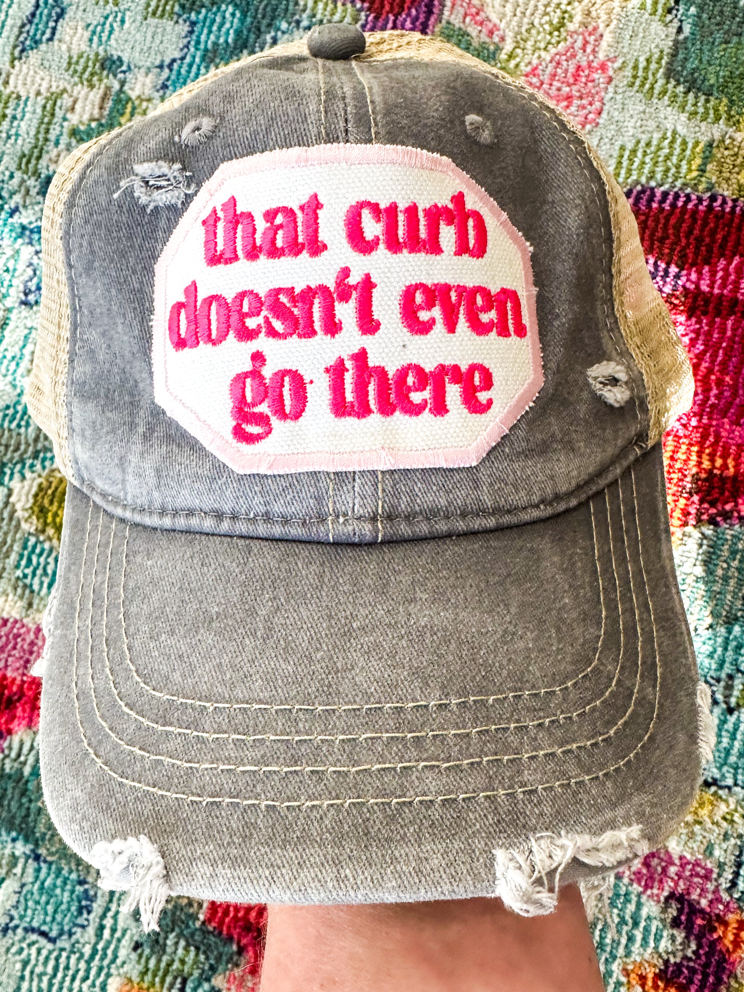 Grayish blue with khaki hat with "that curb doesn't even go there" embroidered patch in hot pink.



Velcro back.