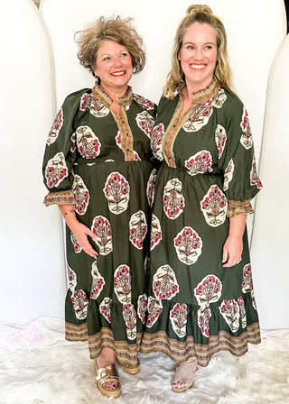 Palm green maxi dress with colorful floral medallion print, orange embroidered trim at neckline, and smocked cuffs