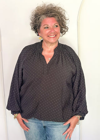 woman in black bubble hem long sleeve top with white dots.
