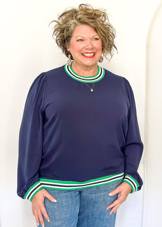 Navy long-sleeve top with green-and-white striped trim at neckline, cuffs, and hem.