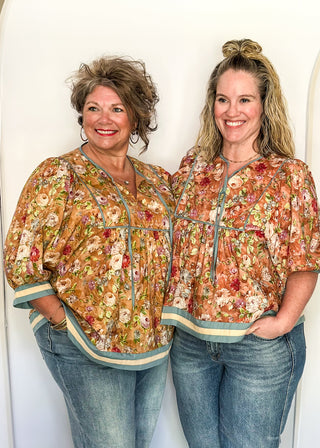 Fall floral Babydoll top with 3/4 puff sleeve, cream and blue strip detail on banding of hem and sleeve. blue ribbon detail on the front and tie at the collar. 