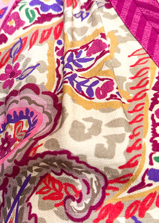 Close-up of a person wearing a colorful paisley print blouse with a pink chevron-patterned collar.