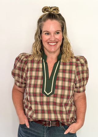 Woman wearing a plaid shirt with a green trim against a white background