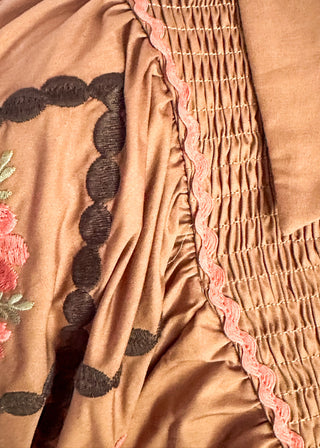 close up of chestnut poplin puff sleeve top with embroidery. 