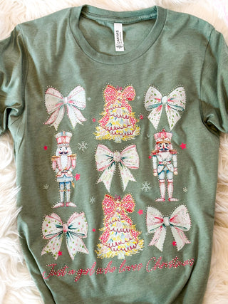 Green t-shirt with decorative bows and nutcrackers on a soft surface