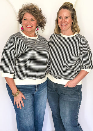 Striped knit dolman top with crew neckline and ribbed trim in black.