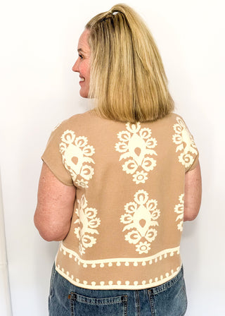 Taupe knit sweater with ivory woven pattern and short sleeves.