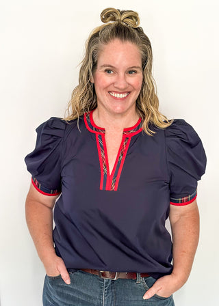 Puff sleeve navy top with red plaid contrast on the sleeve and v-neck.	