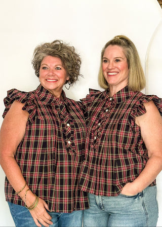 Two women wearing a dark navy plaid top with flutter sleeves and rhinestone buttons.
