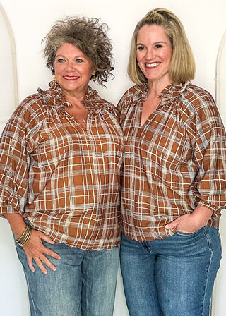 Two women modeling a brown and blue plaid blouse with ruffle collar and 3/4 sleeves.