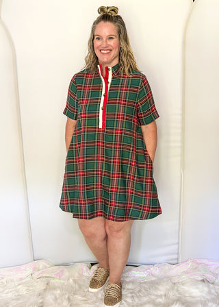 Woman wearing a green plaid dress with a white background