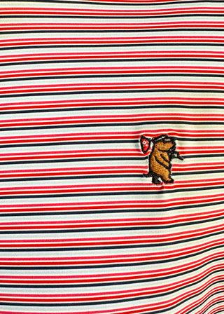 Close-up of a horizontally striped knit fabric with red, black, and off-white stripes, featuring a small embroidered brown bear character holding a red-and-white flag on the chest.