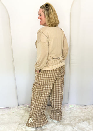 side view of woman modeling gingham bloomer pants with patches and pockets.