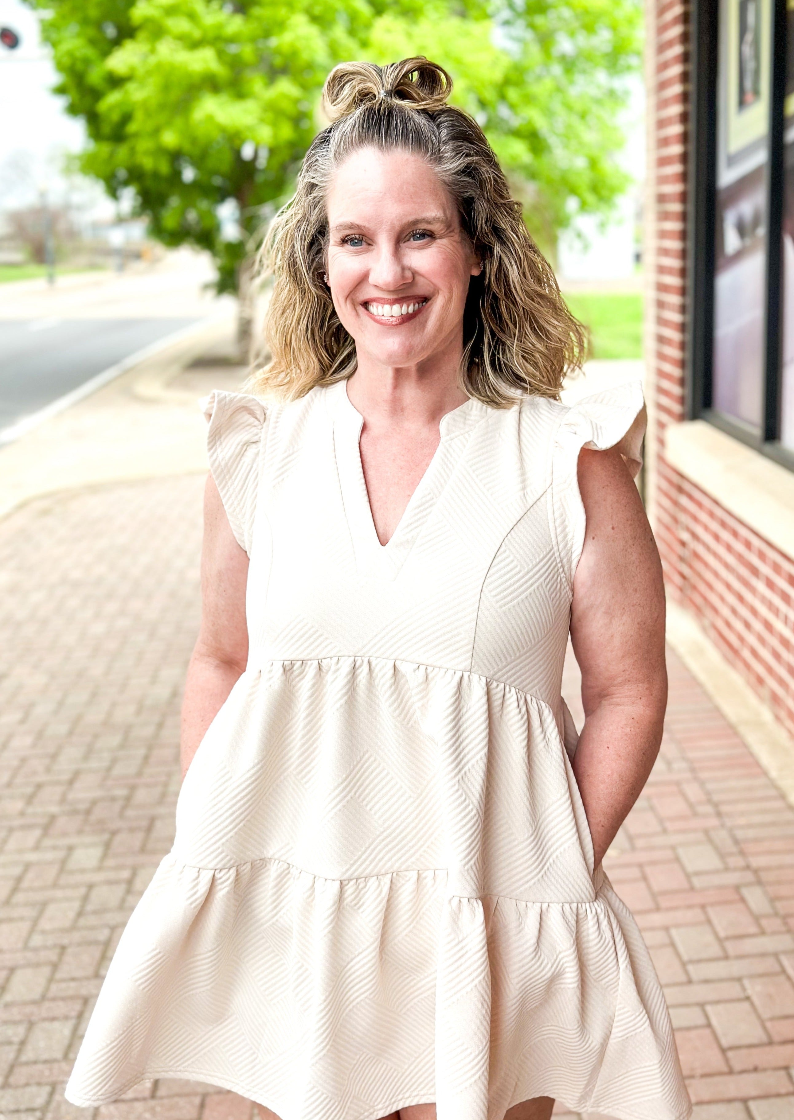 Cream textured tiered dress with ruffle sleeve, pockets, v-neck