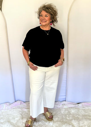 White wide crop Judy Blue jeans with double gold button closure, front patch pockets, high rise fit, and cropped wide leg silhouette with raw hem