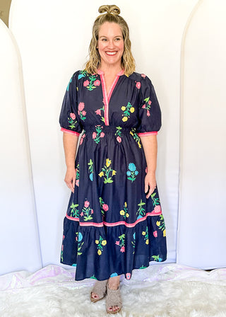 Colorful floral navy midi dress featuring pink contrast trim and a gathered waistline