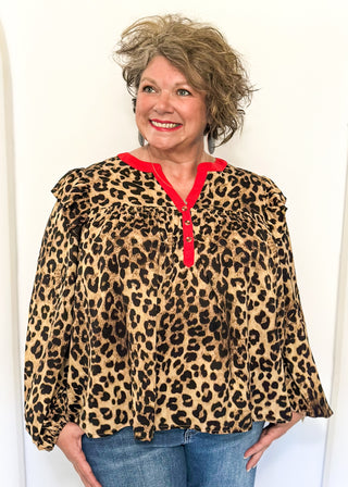 long sleeve leopard print top with red trim v-neck and buttons down the v; ruffle on shoulder 