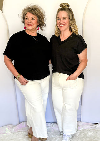 White wide crop Judy Blue jeans with double gold button closure, front patch pockets, high rise fit, and cropped wide leg silhouette with raw hem