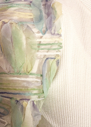 Close up of white ribbed knit top with pastel watercolor puff short sleeves. 