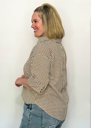 side view of woman modeling a gingham top in brown.