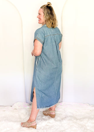 Woman wearing a denim dress standing against a white background