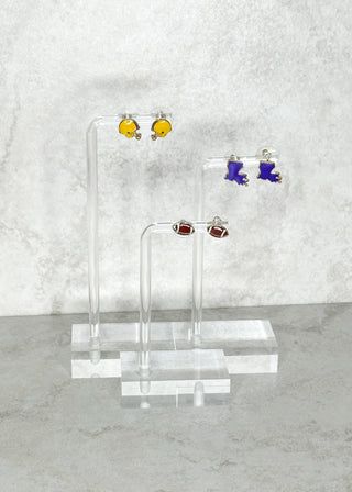 Set of earrings on a clear stand against a marble background