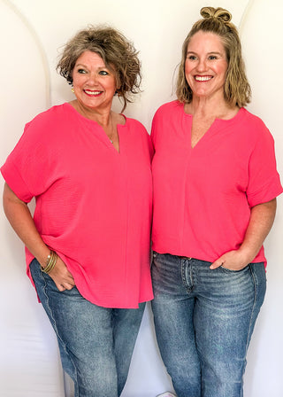 Solid pink textured blouse with a V-notch neckline, short sleeves
