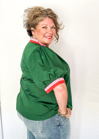 Green Puff Sleeve top with short sleeves and v-neck.  Contrast binding in pink and orange on sleeve and collar. 