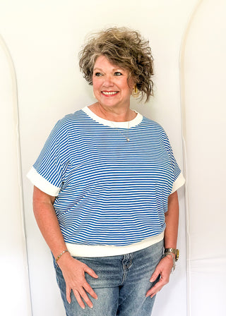 Woman wearing a blue and white striped shirt with a white background