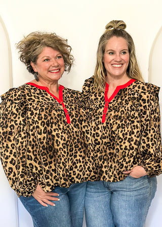 long sleeve leopard print top with red trim v-neck and buttons down the v; ruffle on shoulder 
