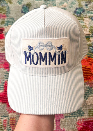 Blue and White Striped snap back cap with embroidered "MOMMIN" patch with bow and floral detail.