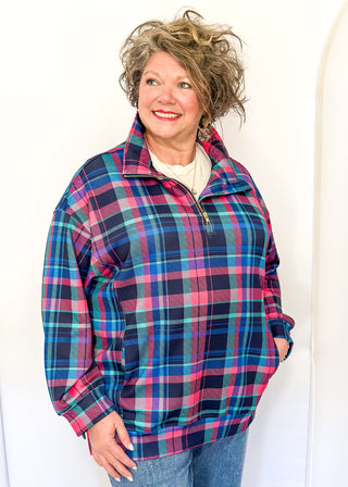 Bright plaid quarter-zip pullover in navy, teal, and pink with front pockets.