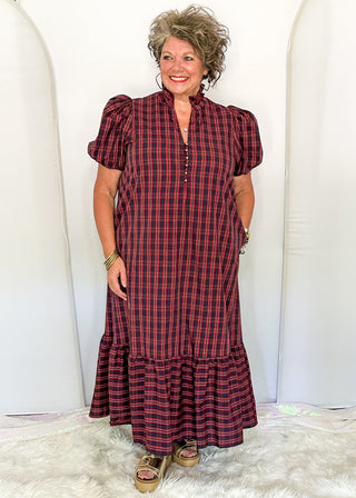 woman wearing a plaid midi dress with puff sleeves and a tiered ruffle hem
