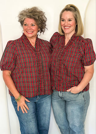 Two women wearing a plaid puff sleeve top in red with short sleeves and a V-neckline.